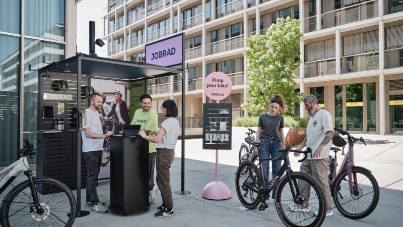 Beratungssituation am JobRad-Stand. Zentral ein Sticker-Aufsteller mit Schild "Pimp your Bike" Beratungssituation am JobRad-Stand. Zentral ein Sticker-Aufsteller mit Schild "Pimp your Bike"