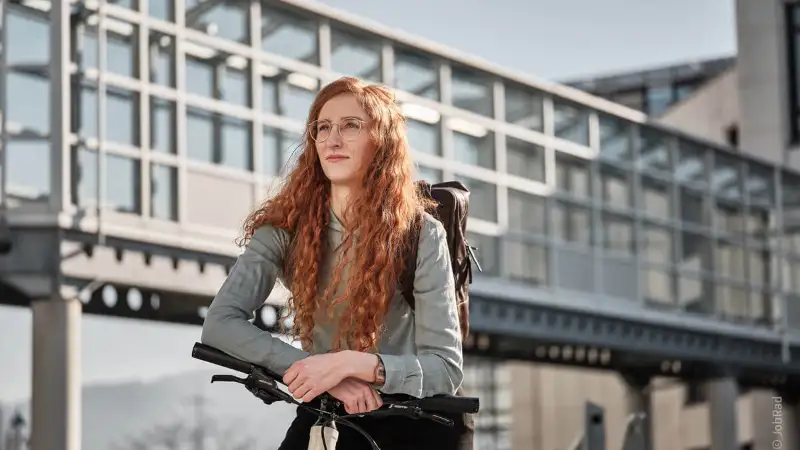 Eine nachdenkliche Frau mit roten Haaren auf ihrem Fahrrad Eine nachdenkliche Frau mit roten Haaren auf ihrem Fahrrad
