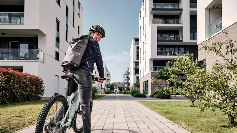 Eine JobRadlerin mit Mountainbike in einer Häuserschlucht