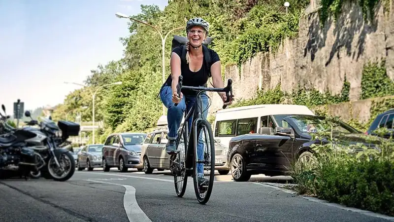 Frau fährt mit JobRad am Stau vorbei Frau fährt mit JobRad am Stau vorbei