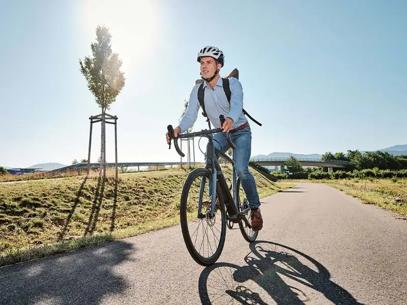 JobRadler auf dem Radweg mit Sonne JobRadler auf dem Radweg mit Sonne