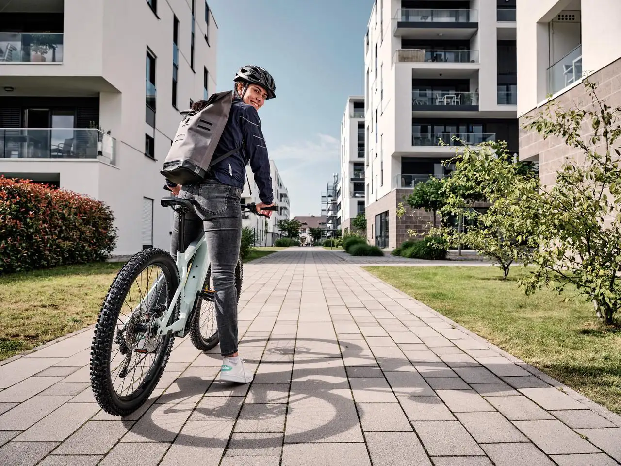 Eine JobRadlerin mit Mountainbike in einer Häuserschlucht