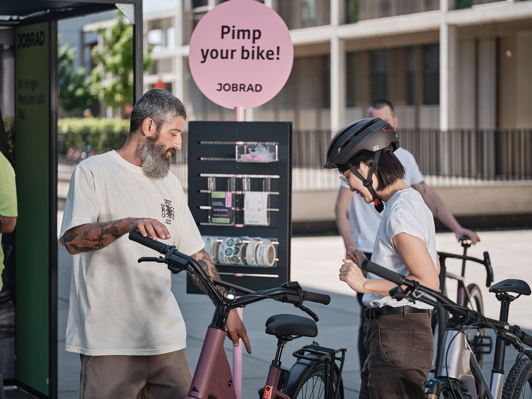 Beratung am JobRad-Stand. Im Hintergrund ein Sticker-Aufsteller "Pimp your bike!"